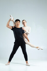 Asian Man and Caucasian Woman Performing As Ballet Dancers On Grey in Studio During Suppots As Classical Dance And Choreography as Ballet Dance Concepts © danmorgan12