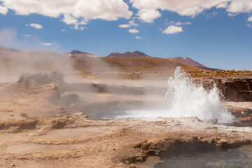 Tatio Geyser, Atacama Desert, Chile. Geyser steam in the desert with blue sky and clouds.