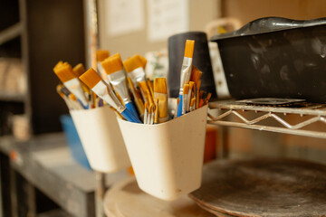 Artist's paintbrushes in studio with warm lighting