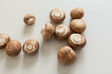 Overhead view of brown mushrooms on white counter
