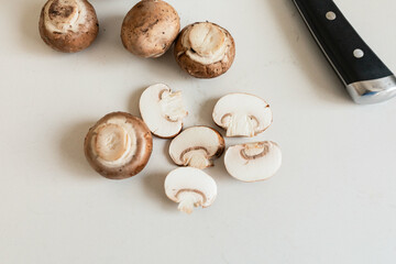 slicing brown mushrooms in kitchen
