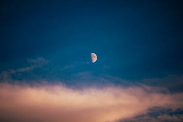 Half Moon in a Colorful Twilight Sky with Soft Clouds