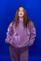 Young girl posing and moving on a blue background	