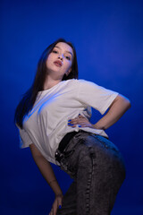 Young girl posing and moving on a blue background	