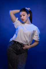 Young girl posing and moving on a blue background	