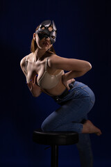Young girl posing and moving in a black studio with colored light	