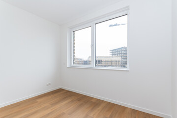 interior empty basic bedroom in modern new build residential smart house. crane and scaffold construction site through glass window. Plain white walls and wood effect vinyl flooring make blank canvas