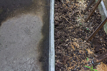 Square Cement Planter Box Filled with Organic Compost Soil on Old Concrete Floor. Sustainable Living Concept.