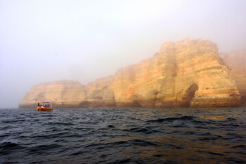 Obraz premium foggy landscape, the Algarve rock formation is a unique and amazing natural wonder located in the coastal town of Porches, Portugal