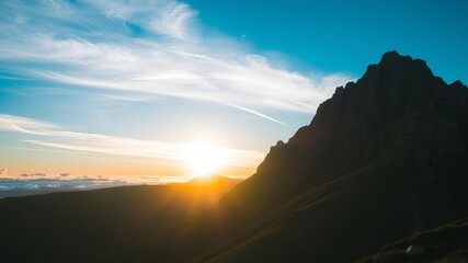 Fototapeta premium Panoramic view of high mountain range bathed in morning sunlight, creating a stunning natural landscape, rugged, fresh, blue sky