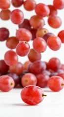 Falling red grapes on white background emphasizing freshness and motion