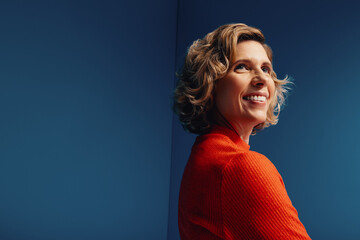 Confident middle-aged businesswoman in a vibrant monochromatic set with blue and orange colorblocking, looking determined