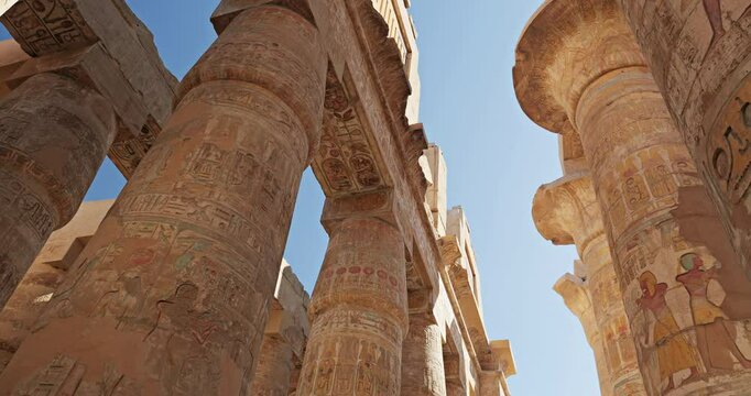 Up view between the engraved stone pillars of Luxor temple in Egypt