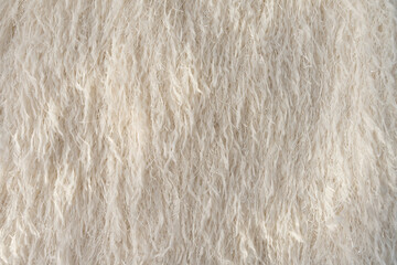 Feathered textured fabric with metallic threads in beige colour, fashion textile close-up.