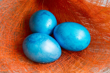 Three Blue Easter eggs on orange background