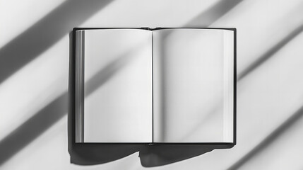 Sunlit blank notebook with soft shadows of leaves on textured surface, perfect for creative writing, journaling, branding, and design projects with a calm, natural atmosphere