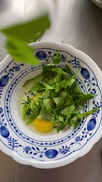 Spinach falling in bowl with eggs, top view