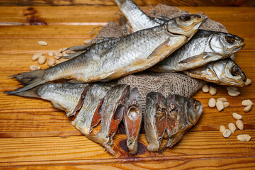Dried roach with roach roe, carefully sliced ​​and laid out on a rough wooden board.