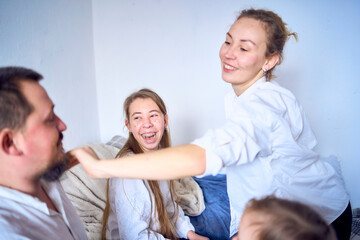 Fototapeta premium a family plays by painting each other's faces with gold glitter during a Christmas party at home