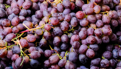 Dense arrangement of grapes, highlighting their round shape, smooth skin, and vibrant purple or green hues. Ideal for fruit, wine, or healthy eating concepts. Texture, background.
