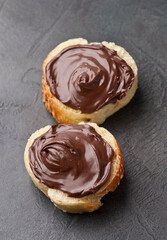Slice of bread with chocolate spread on concrete backgrounds.