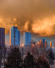 Orange clouds over multi-story buildings in the city.