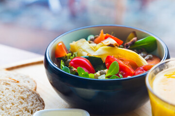 Black ceramic bowl with healthy colorful organic fresh salad