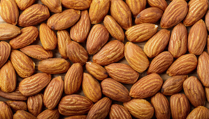Fototapeta premium Repeating pattern of raw or roasted almonds, emphasizing their textured surface and warm beige tones. Ideal for healthy snacks, baking, or natural food concepts. Texture, background.