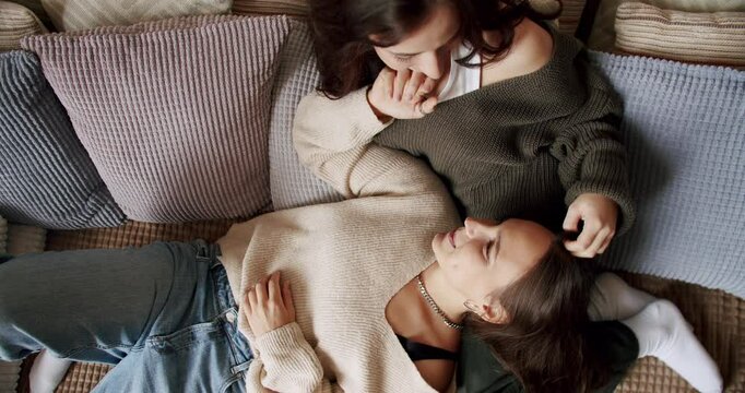 Women Couple Lesbian rest at home. Embrace and holding each other. Love and kiss. Romance lesbian couple enjoying. LGBT rights, Lesbian family. Two women sharing love and support holding hands.