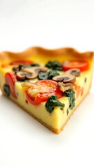 Closeup of a colorful vegetable quiche slice with fresh ingredients and golden crust
