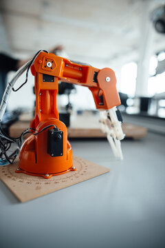 Orange robotic arm in a modern laboratory setting