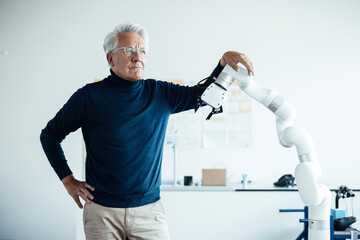Engineer in a laboratory with a robotic arm