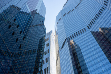 Reflective glass skyscrapers in The City, London, emphasizing geometric lines, financial power, and contemporary urbanism.