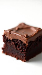 Closeup view of a rich chocolate brownie topped with creamy frosting on a light surface