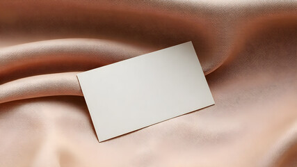 Fototapeta premium A premium business card mockup with gold foil embossing, placed on luxurious textured fabric. Soft lighting enhances the high-end branding, perfect for corporate identity presentations