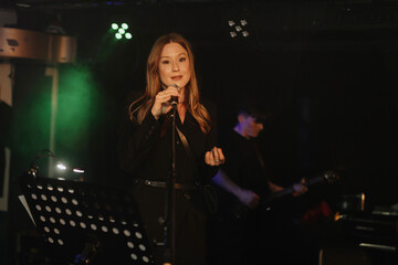 Smiling beautiful singer singing on stage