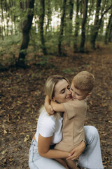 Fototapeta premium Mother and Son Hugging Tightly in a Serene Forest Setting