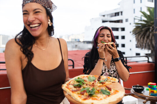 Happy friends having pizza at restaurant terrace - Powered by Adobe