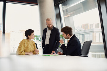 Colleagues discussing business strategy in a modern office boardroom
