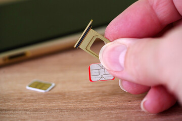 Person inserting a sim card into back of mobile phone, Sim card in tray being inserted into phone