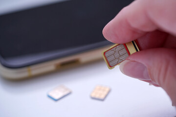 Person inserting a sim card into back of mobile phone, Sim card in tray being inserted into phone