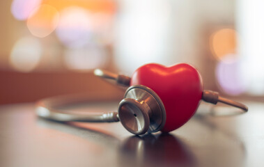 Red heart shape exercise ball with doctor physician's stethoscope on hospital background, hospital...