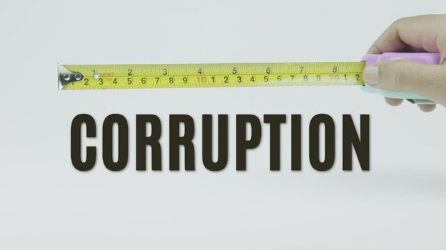 "Corruption" text with a tape measure on a white background, symbolizing precision, accuracy, and the concept of unethical behavior or compromise in a clean, minimal video