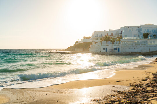 Scenic view of Paralia Platis Gialos beach in Mykonos during autumn with waves and sunset.