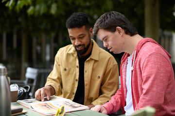 Special educator using multi sensory teaching methods with young man with Down syndrome.