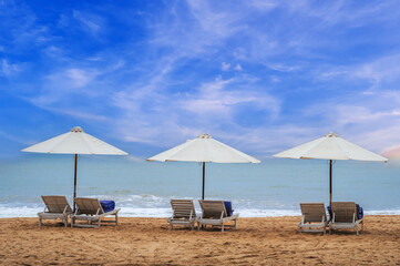 Scenic view of the sandy beach with umbrellas and deck chairs on the shoreline.