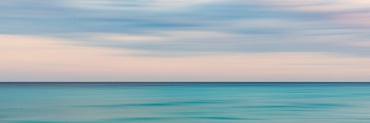 Abstract seascape of the Mediterranean Sea in Menton, France with blurred sky and water.