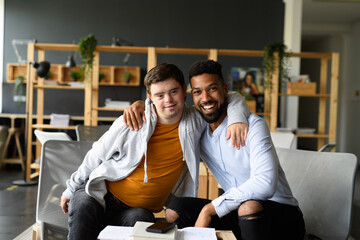 Portrait of young student with Down syndrome and special educator teacher in classroom.
