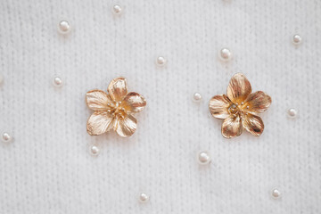 Delicate floral jewelry on textured fabric with pearls for elegant styling