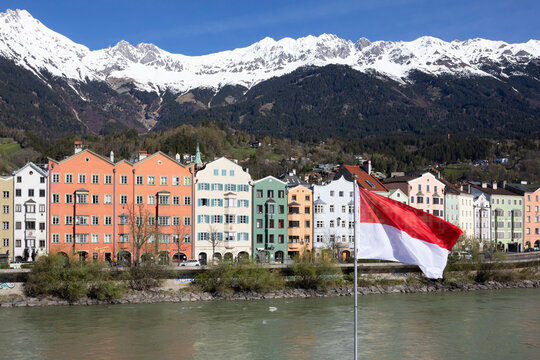 Colorful buildings along the Inn River in Innsbruck, Austria with the Nordkette and Karwendel Mountains in the background